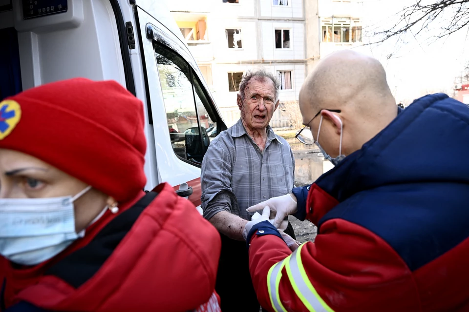 Służby udzielają pierwszej pomocy osobom rannym po bombardowaniu miasta Czuhujew